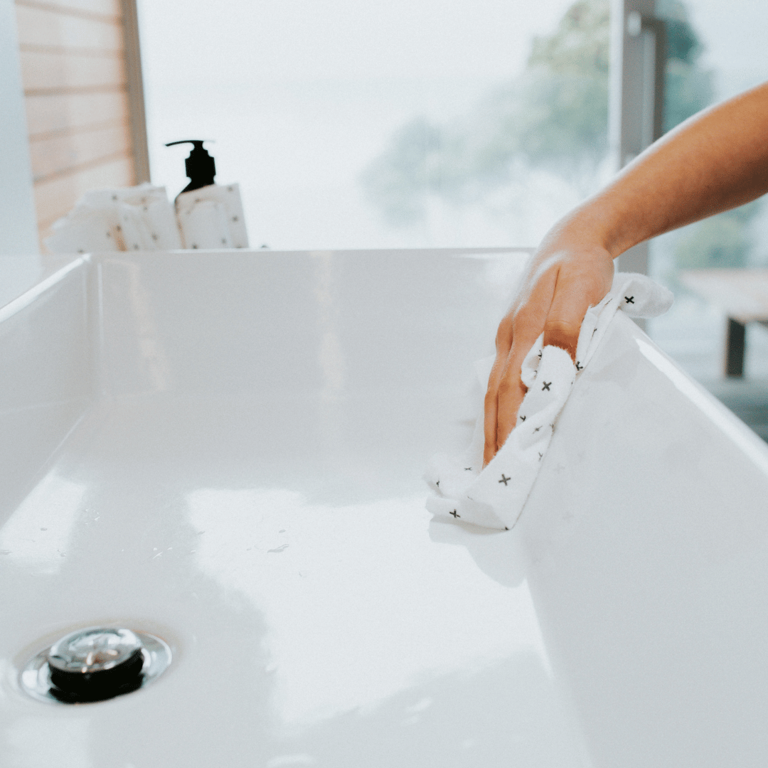 Person cleaning bathroom sink with bamboo towel
