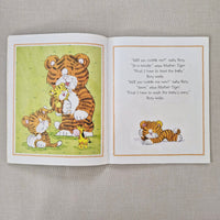 Open book with illustrations of a tiger and text on a textured gray background