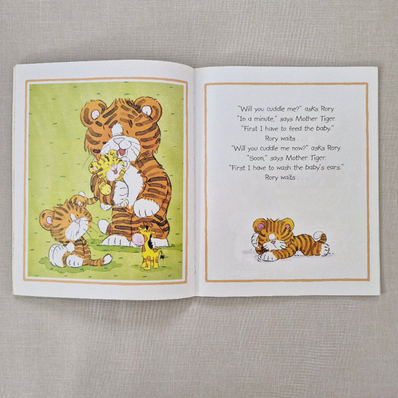 Open book with illustrations of a tiger and text on a textured gray background