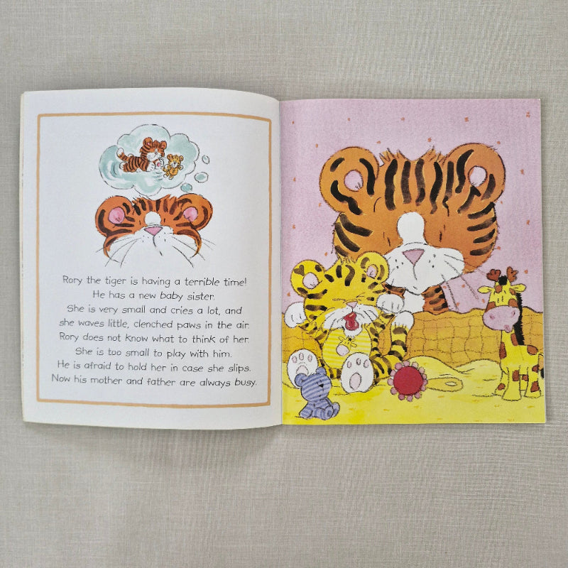 Illustrated book page with cartoon tigers on a textured fabric background
