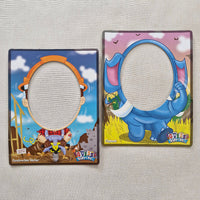 Two cartoon-themed mirrors on a textured surface