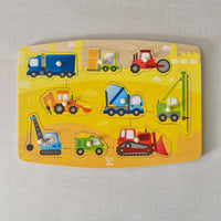 Children's puzzle with toy construction vehicles on a yellow background