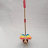 Toy with colorful butterfly wings and a red handle on a light gray background