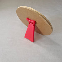 Round brown object with a red clip on a light grey background