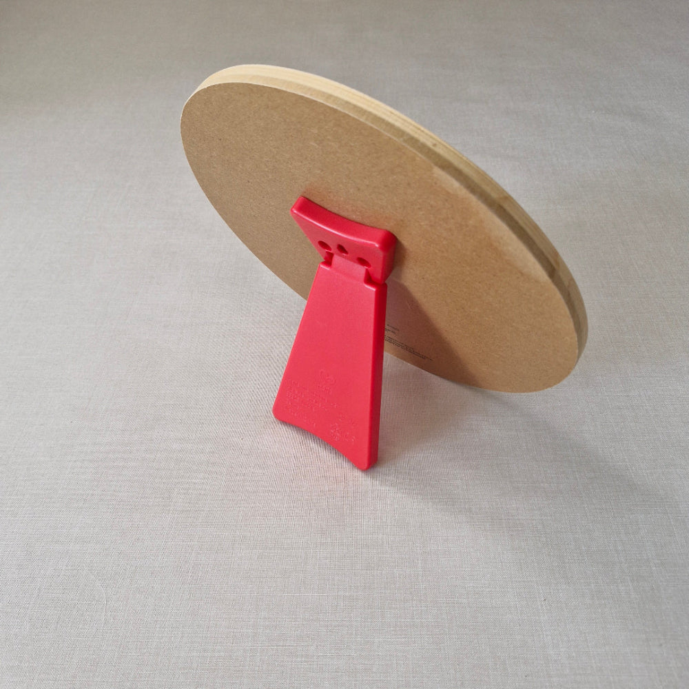 Round brown object with a red clip on a light grey background