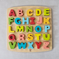 Wooden alphabet puzzle with colourful letters on a light grey background