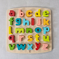 Colourful wooden alphabet puzzle on a light grey background