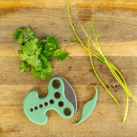 Green herb stripper and chopper on chopping board with parsley