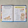 Open book showing illustrations of a Golden Retriever puppy with text and colour swatches.