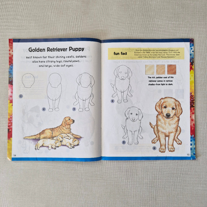 Open book showing illustrations of a Golden Retriever puppy with text and colour swatches.