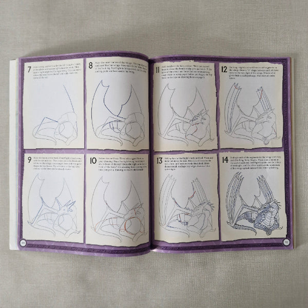 Open book with step by step illustrations to draw a dragon and text on a textured surface