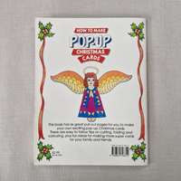 Book back cover for 'How to Make Pop-Up Christmas Cards' with an angel illustration on a grey background