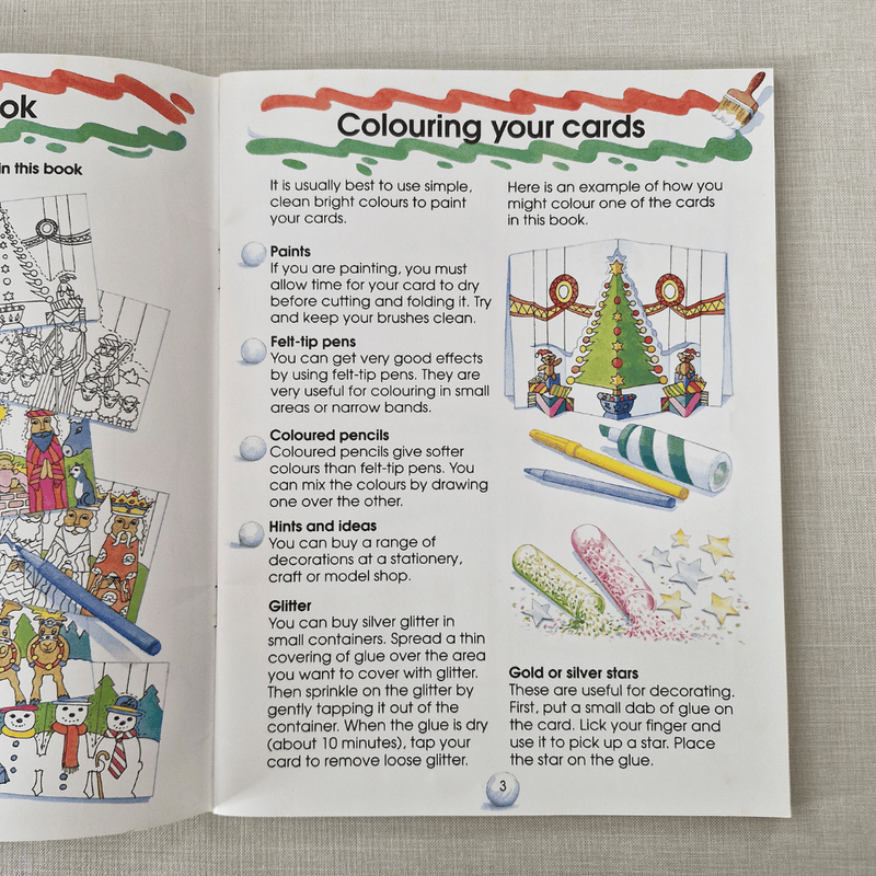 Open book with instructions on colouring cards, featuring illustrations and text.
