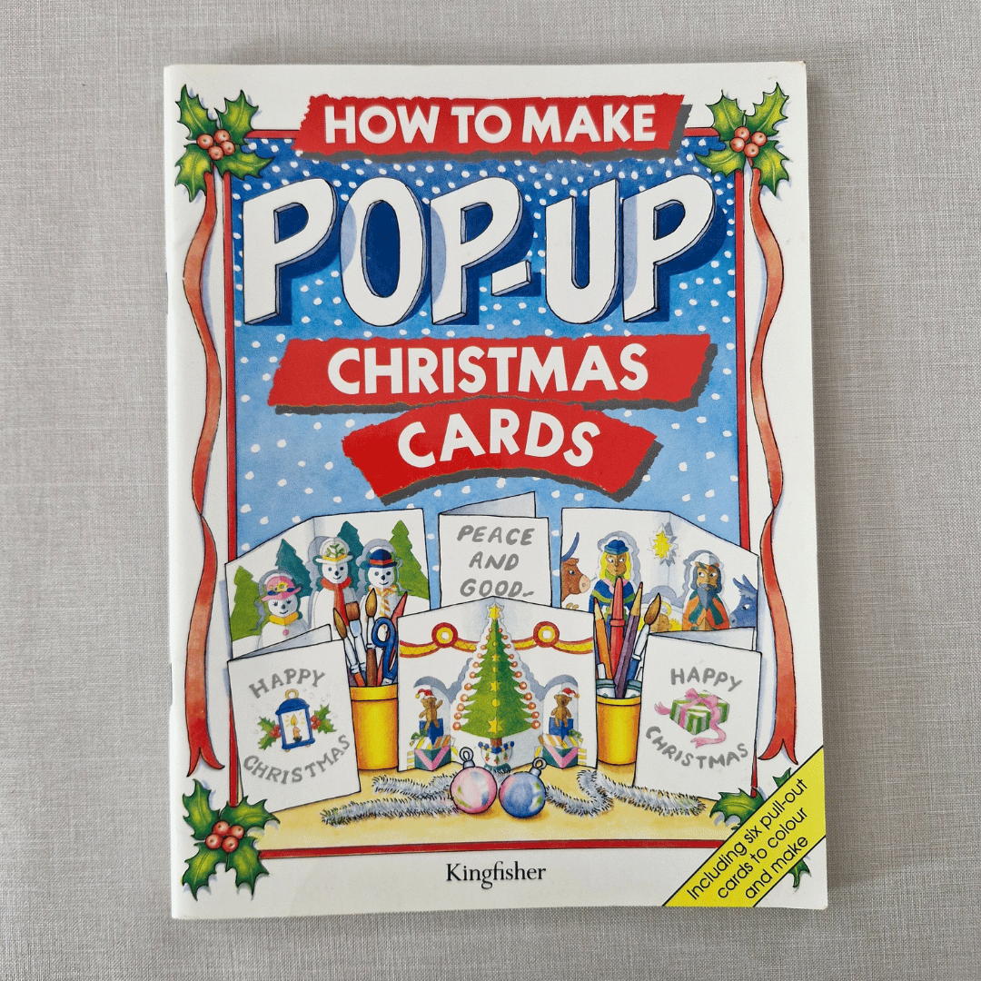 Book titled 'How to Make Pop-Up Christmas Cards' by Kingfisher on a grey textured background