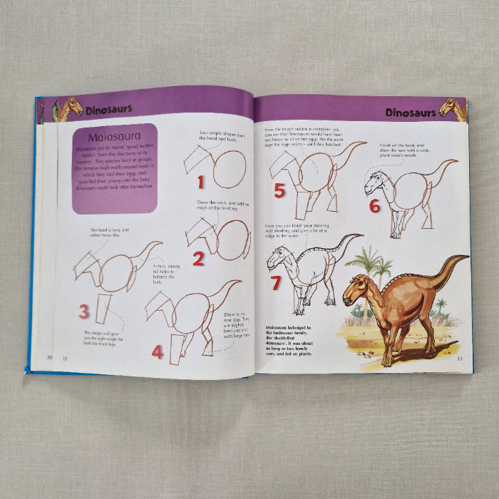 Open book with dinosaur illustrations and text on a textured surface