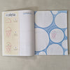 Open book with blue and white circular patterns and red jellyfish illustrations on a beige background