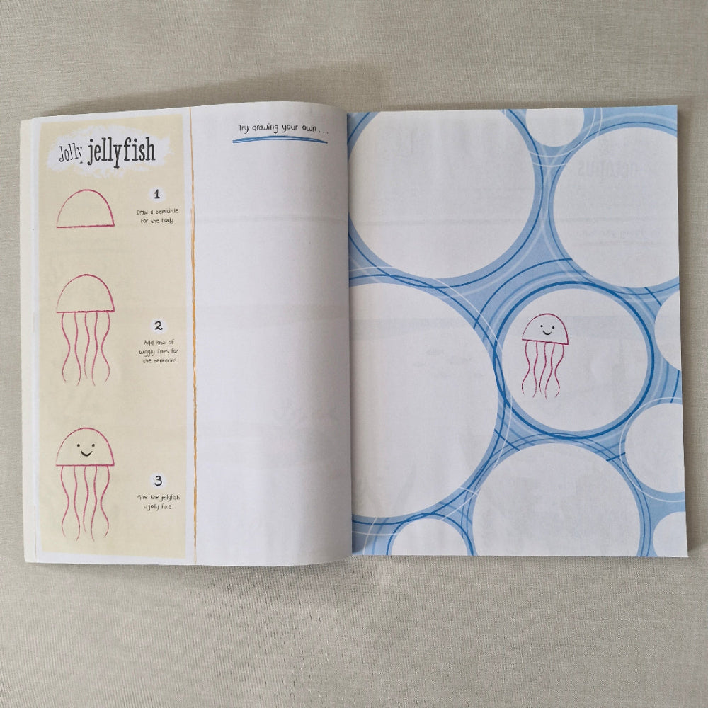 Open book with blue and white circular patterns and red jellyfish illustrations on a beige background