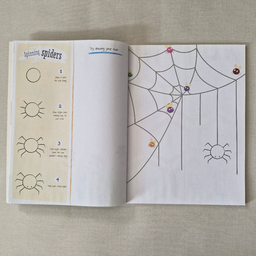 Open book with spider web and sun illustrations on a textured surface