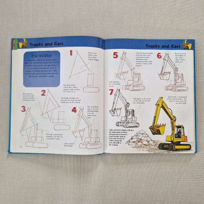 Open book with illustrations of a excavator on a textured surface