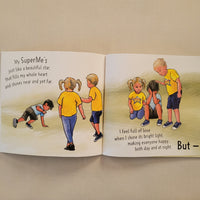 An open children's book spread photographed from above on a beige fabric surface. The pages show illustrated children in yellow shirts and blue shorts, with text including 'But' and 'My Super.