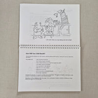 Spiral-bound book with cartoon illustration and text on a textured surface