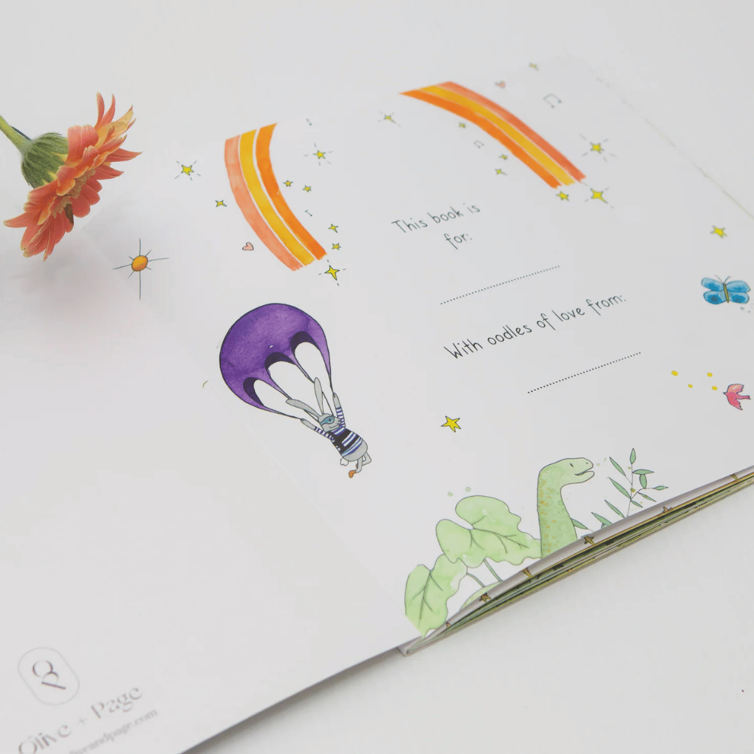 Children's book with illustrations of a hot air balloon, rainbow, and dinosaur on a white background.