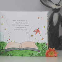 Illustrated book with a message about magic and a plush rabbit toy in the background
