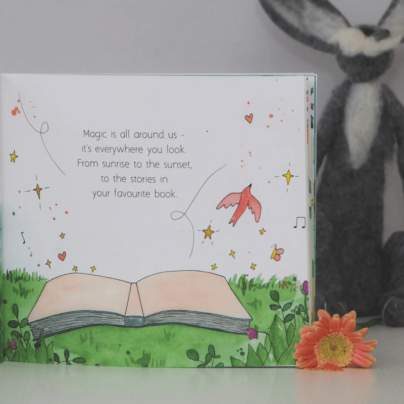 Illustrated book with a message about magic and a plush rabbit toy in the background