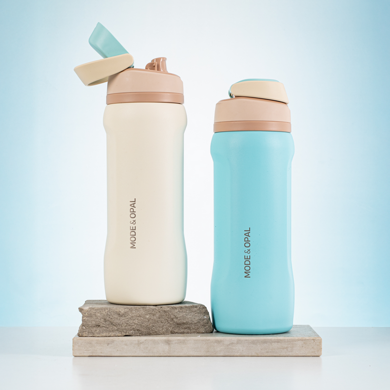 Two water bottles, one beige and one light blue, with 'MODE & OPAL' branding on a light blue background.