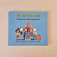 Book titled 'It's OK To Be You! Feeling Good About Growing Up' by Claire Patterson and Lindsay Quinter on a beige background