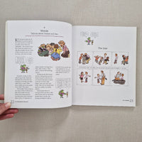 Open book with illustrations and text on a beige fabric background