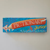 Pictionary Junior game box on a plain background