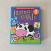Box of 'Old MacDonald had a farm' lacing cards with a cow illustration on a beige background