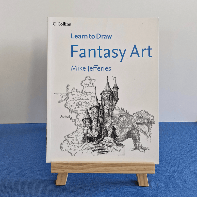 Book titled 'Learn to Draw Fantasy Art' by Mike Jefferies on a stand against a blue and gray background.