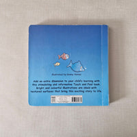 Blue book with fish illustrations on a textured beige surface