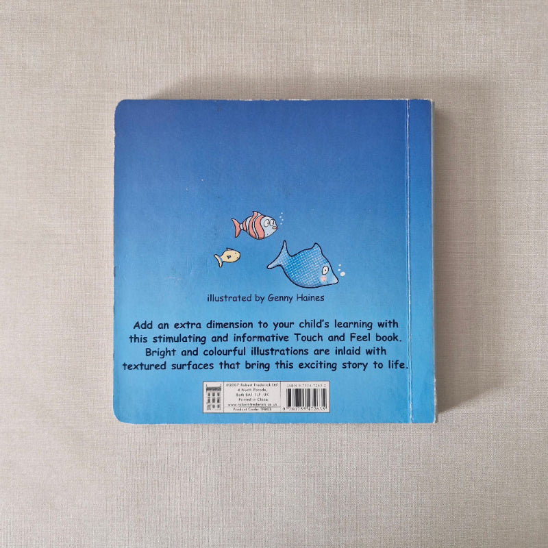 Blue book with fish illustrations on a textured beige surface