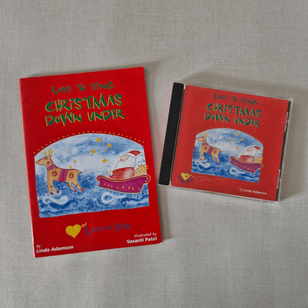 Red book and CD titled 'Love to Sing Christmas Down Under' on a grey surface.