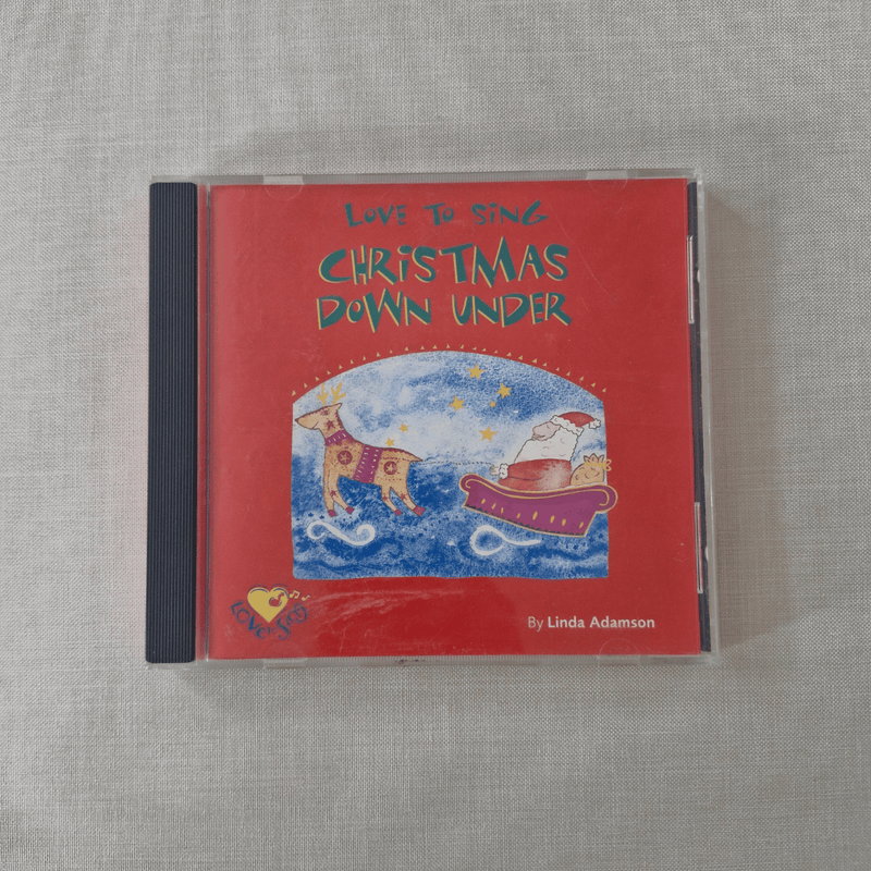CD cover of 'Love to Sing Christmas Down Under' by Linda Adamson on a textured gray surface