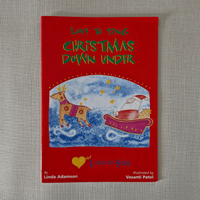 Red book cover titled 'Love to Sing Christmas Down Under' with illustrations of a dog and a reindeer on a grey background.