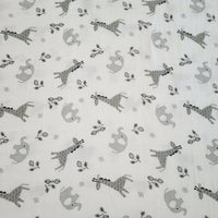 piece of fabric showing the African elephant and giraffe animals depicted on the swaddle blanket