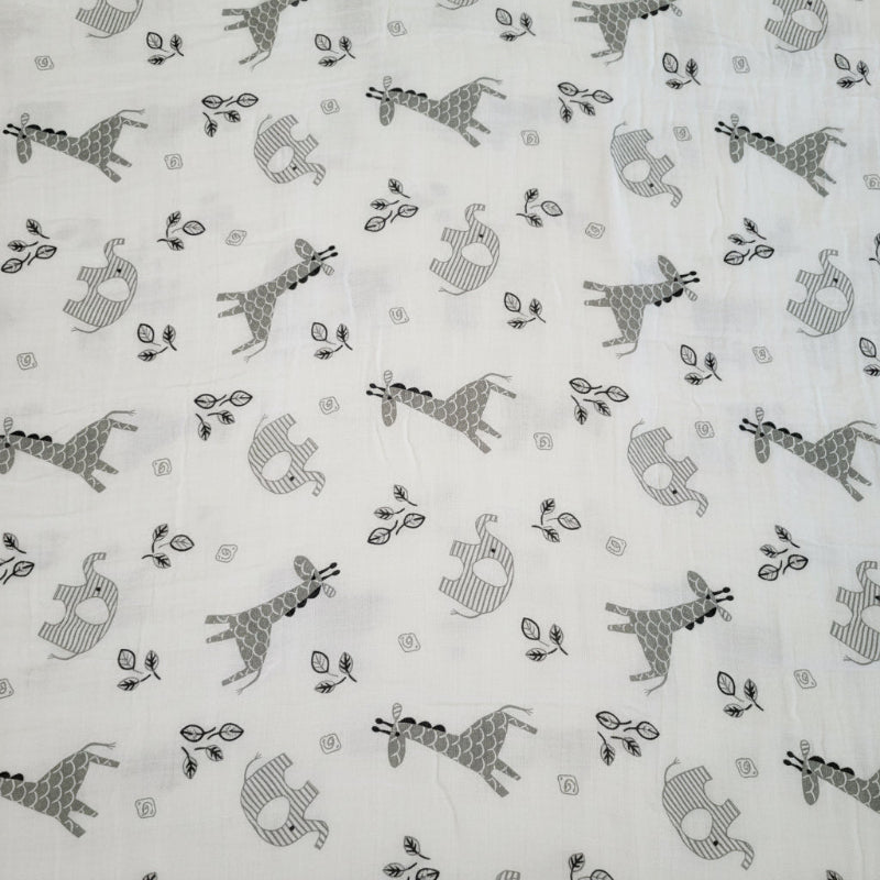 piece of fabric showing the African elephant and giraffe animals depicted on the swaddle blanket