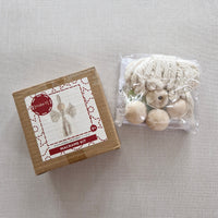 Crafting kit with yarn and beads on a textured surface