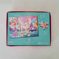 A jigsaw puzzle box labeled 'MAGICAL UNICORN' shown from the back, featuring a colourful illustration of a pink unicorn, a giraffe, a dog, and other fantasy animals on a turquoise background. The box has a red inner border and includes text noting 100 pieces.