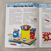 Open book with colouring and craft instructions on a textured surface