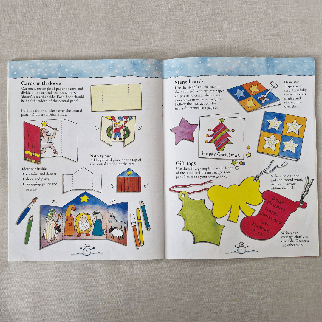 Open book with Christmas-themed craft activities on a grey surface