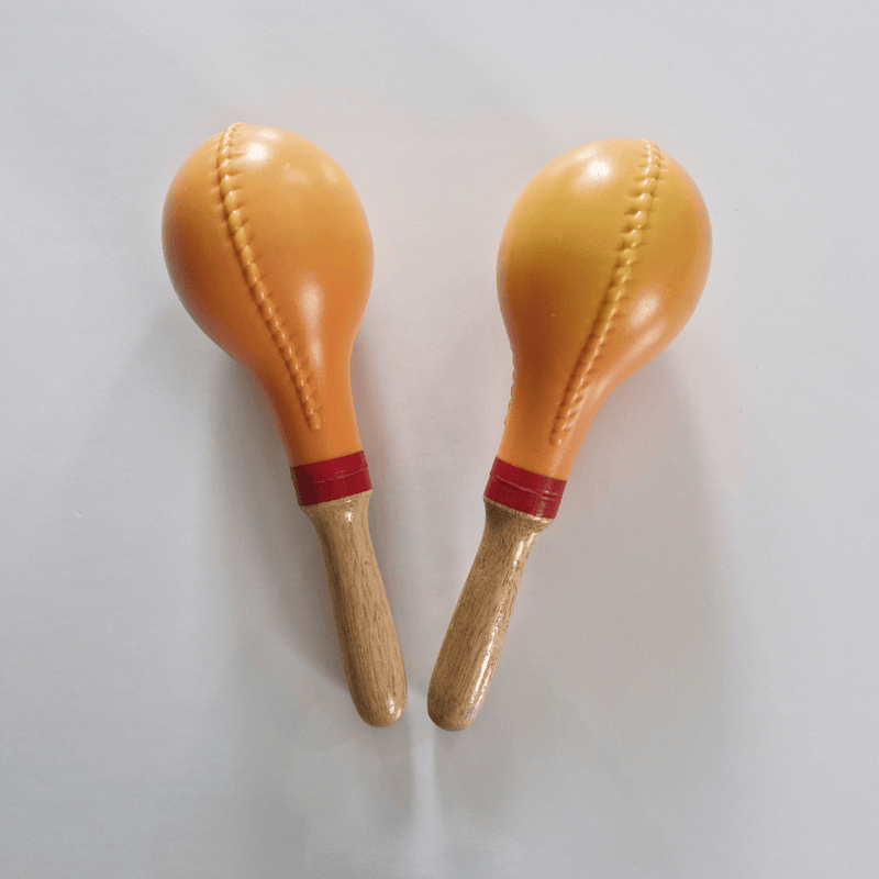 Two maracas with wooden handles on a light gray background