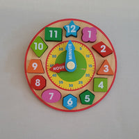 Colorful children's wooden clock puzzle on a plain background