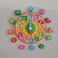 Colourful wooden children's clock with removable numbers and clock hands on a white background