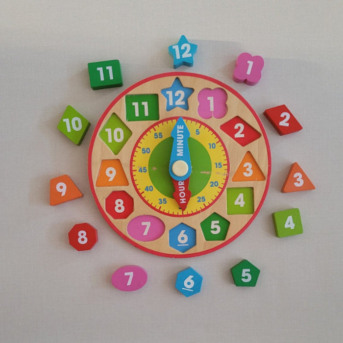 Colourful wooden children's clock with removable numbers and clock hands on a white background