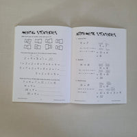 Two pages from a maths book with arithmetic strategies on a beige surface